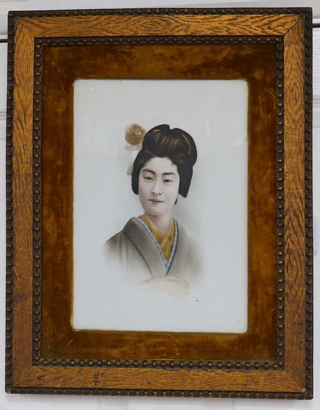 A framed Japanese painted porcelain plaque of a Geisha, 24cm wide, 33cm high. Condition - fair